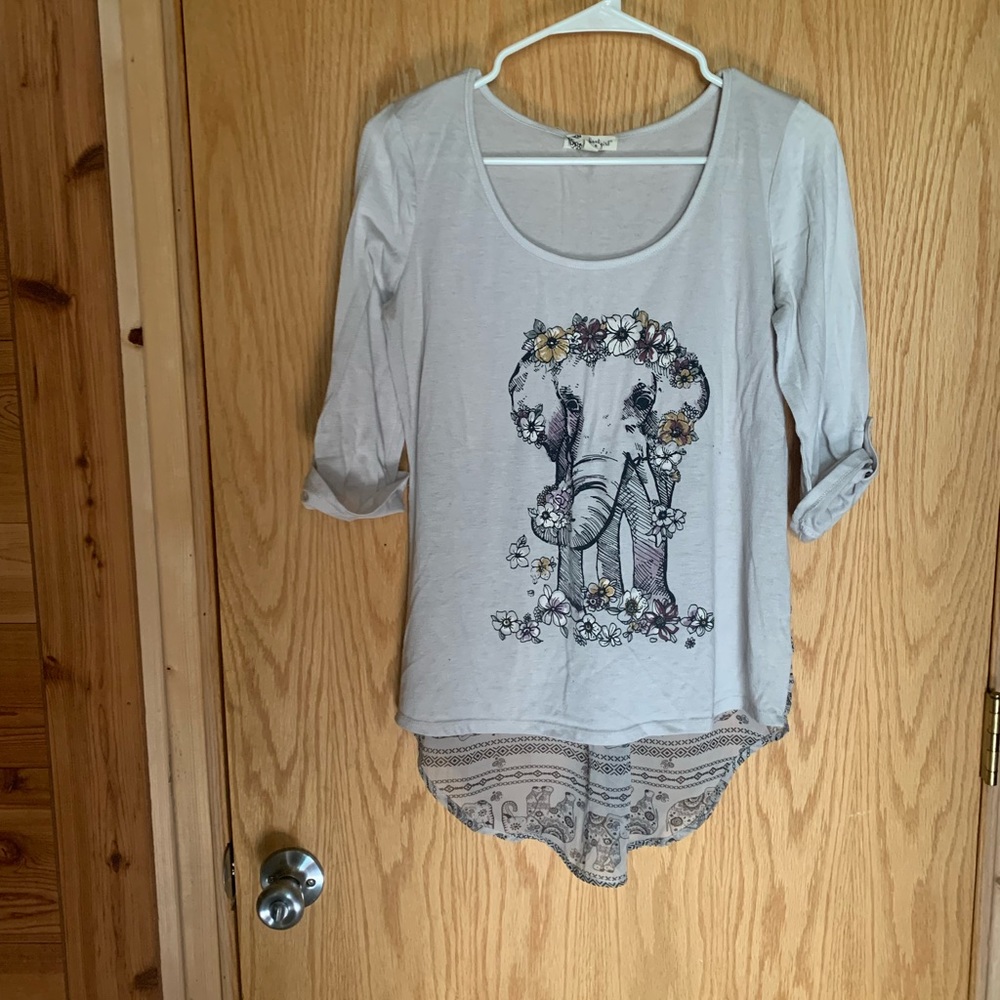 A  3/4 sleeve shirt with elephant print.
